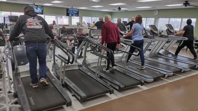 People walking on treadmills that are side-by-side