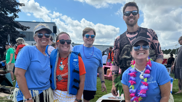 Several people wearing sun glasses smiling at the camera
