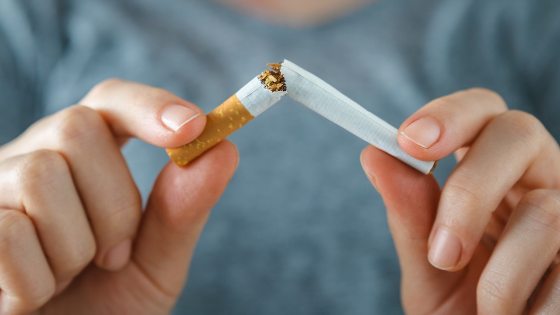 Two hands holding a broken cigarette