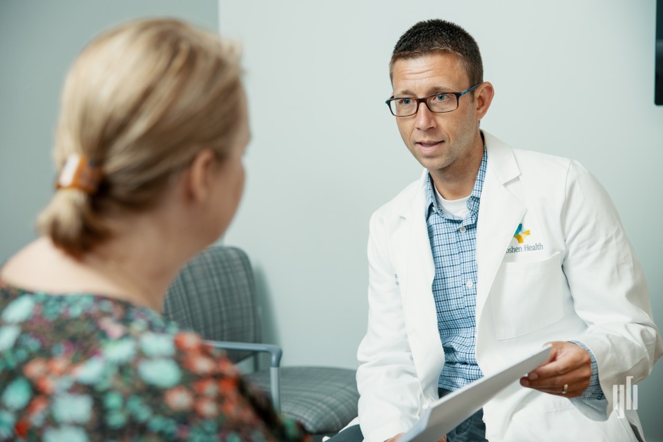 Doctor and patient sitting on chairs having a discussion