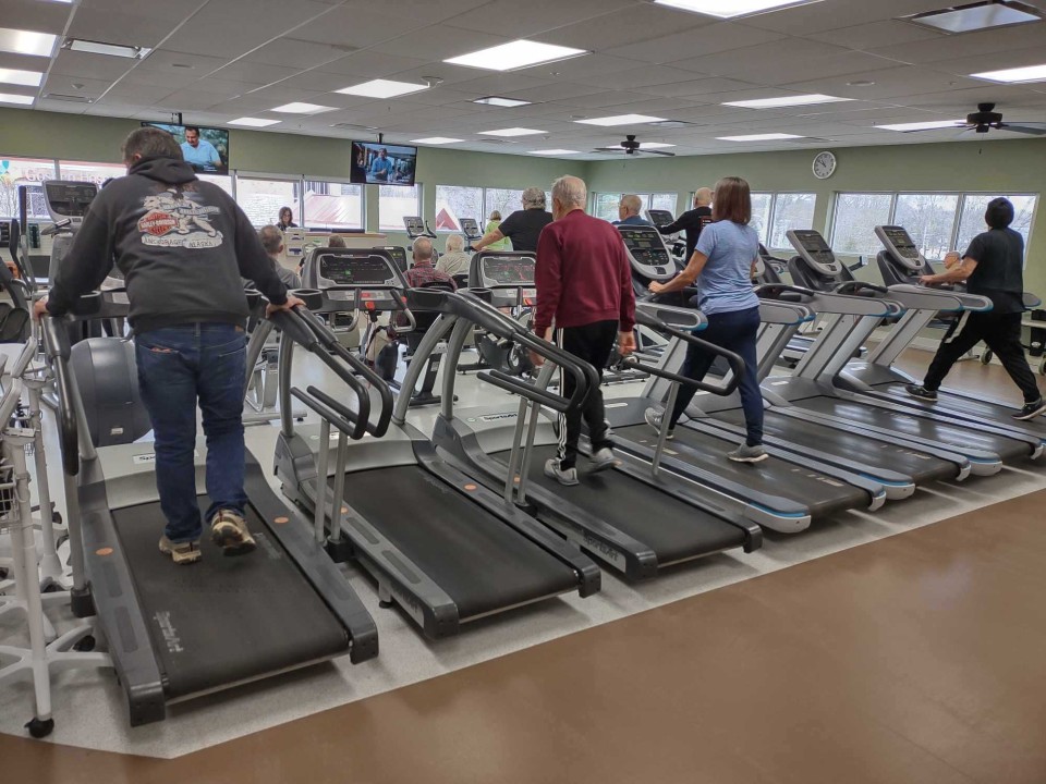 People walking on treadmills that are side-by-side