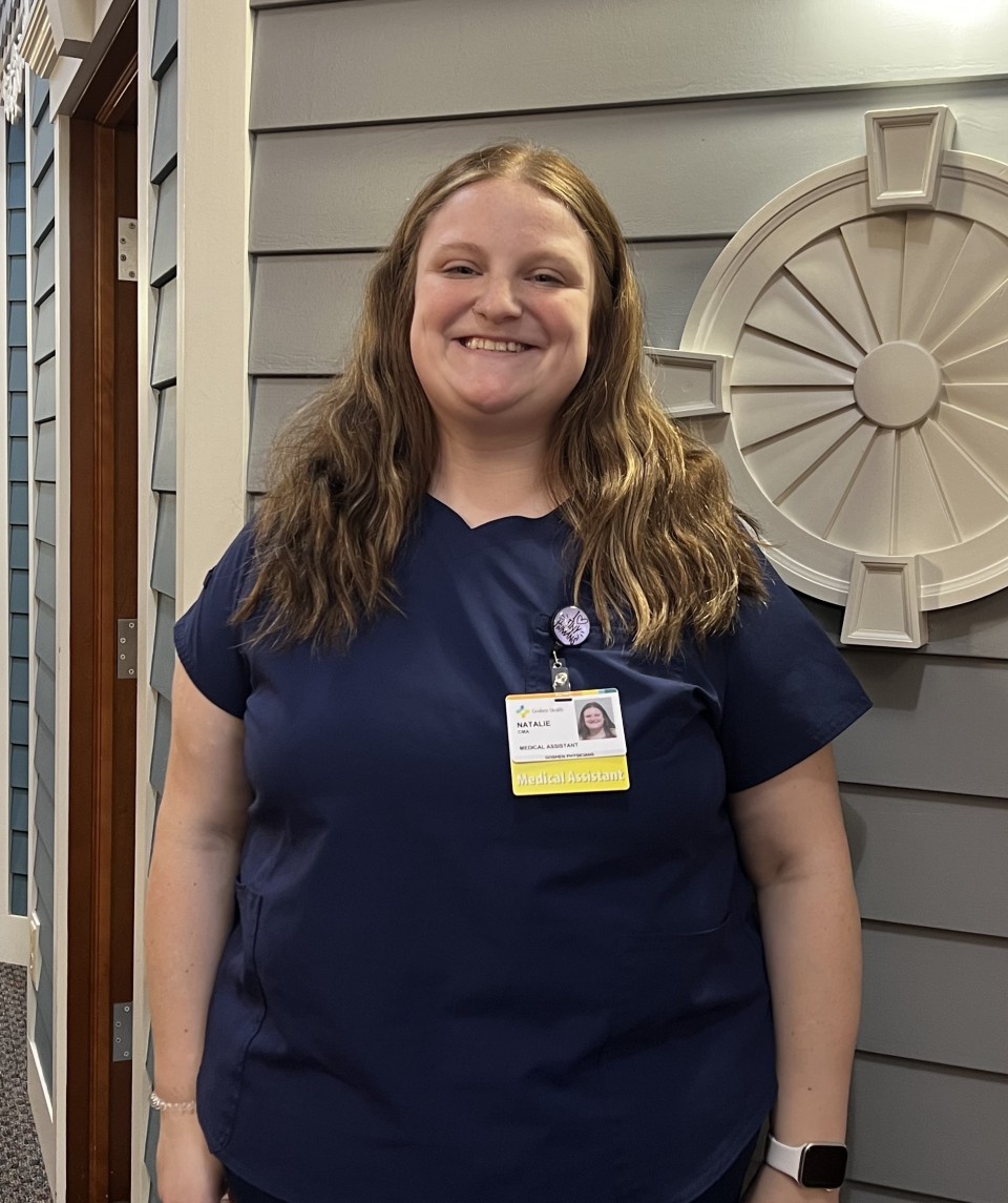 Woman standing in front of a wall smiling