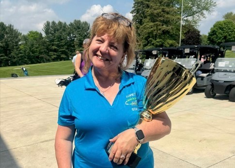 Woman smiling while holding a trophy