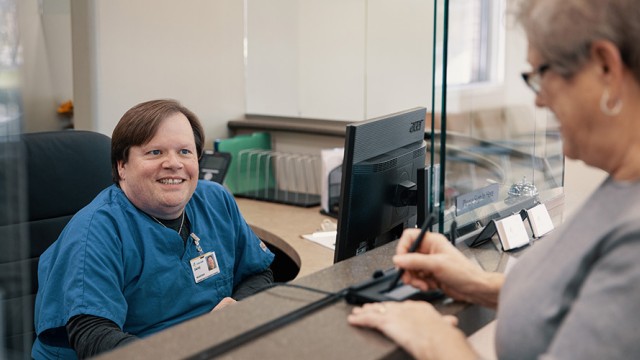 Patient standing at the counter, checking in for a procedure