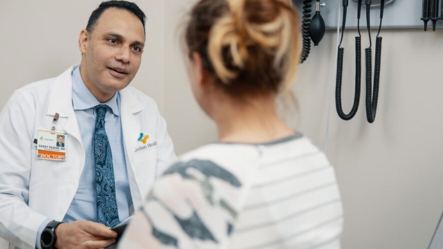 Smiling doctor facing a patient in an exam room