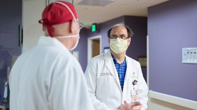 Doctors with masks on facing each other