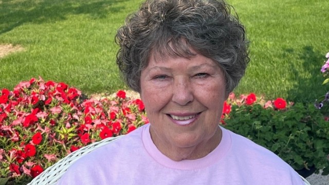 Woman smiling with flowers behind her