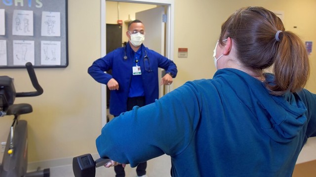 Rehabilitation professional showing patient how to stretch