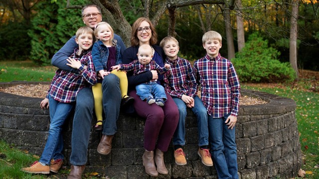 Large family sitting together on a retaining wall