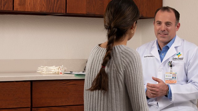 Doctor in white lab coat facing patient in examining room