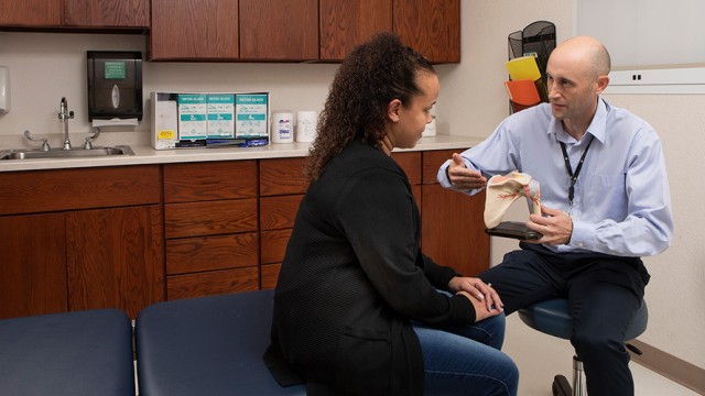 Doctor talking to patient about a model of a shoulder