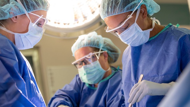 Doctors with masks and gloves performing a procedure