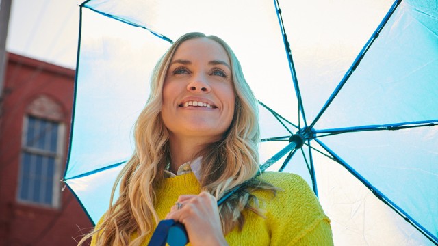 Woman with an umbrella looking up and smiling