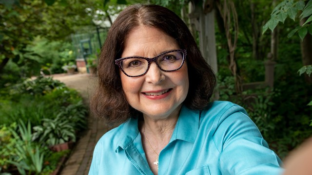 Woman smiling with trees and a footpath in the background