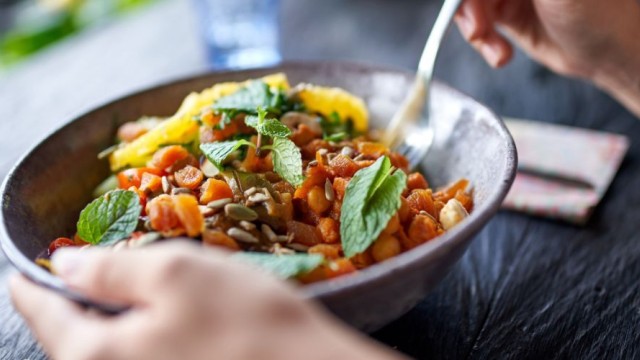Hands holding a bowl of healthy food