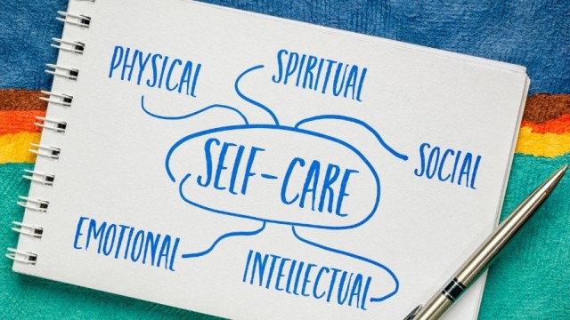 Notepad and pen with several single words describing aspects of self-care