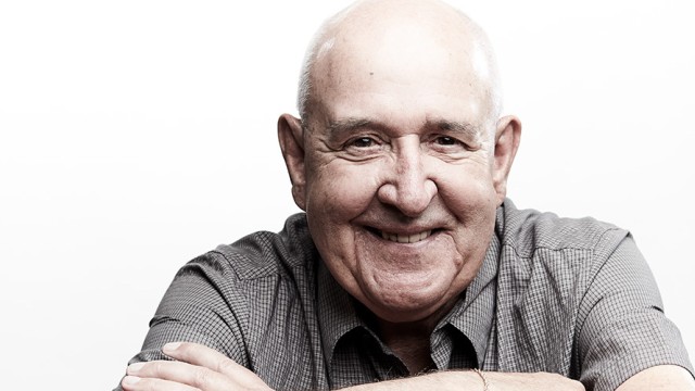 Older man smiling with his arms crossed