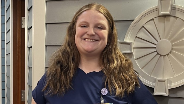 Woman standing in front of a wall smiling