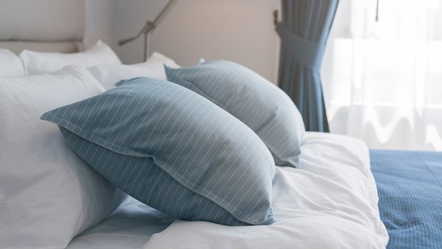 Bed with pillows in front of a window