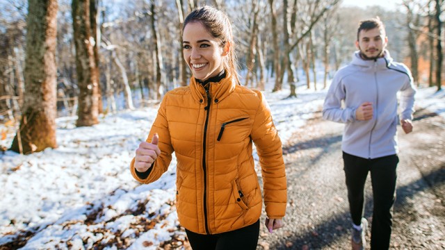 Couple walking on a park sidewalk during the winter