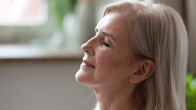 Profile of older woman relaxing with her eyes closed
