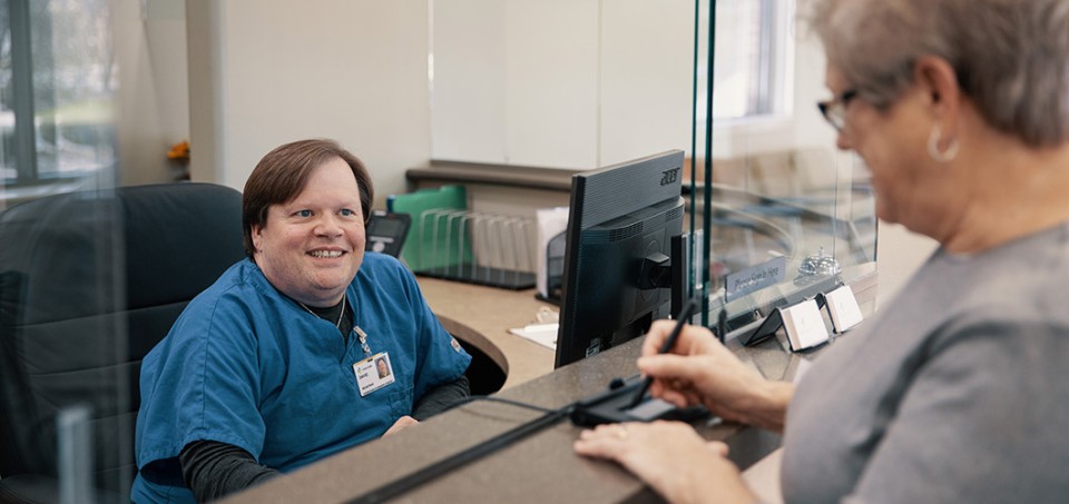 Patient standing at the counter, checking in for a procedure