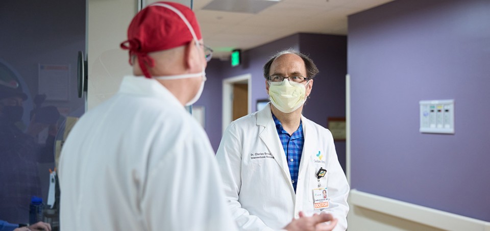 Doctors with masks on facing each other