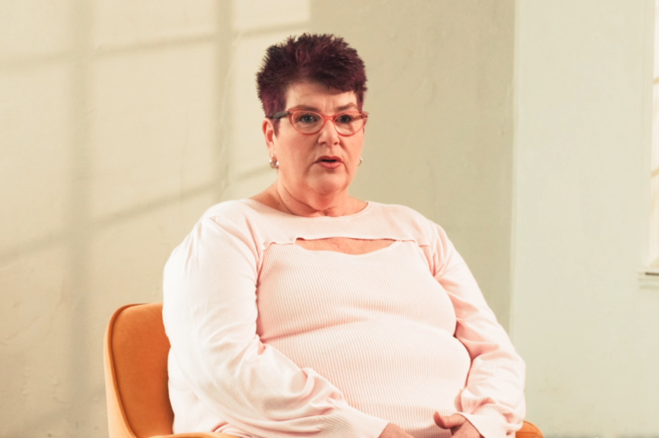 Woman sitting in a chair in front of a blank wall