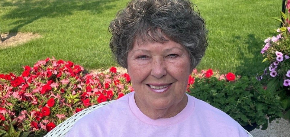 Woman smiling with flowers behind her