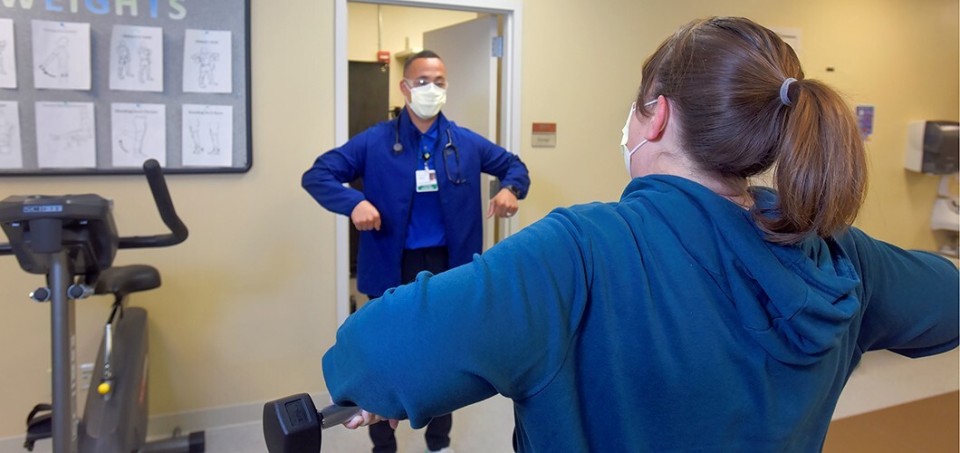 Rehabilitation professional showing patient how to stretch