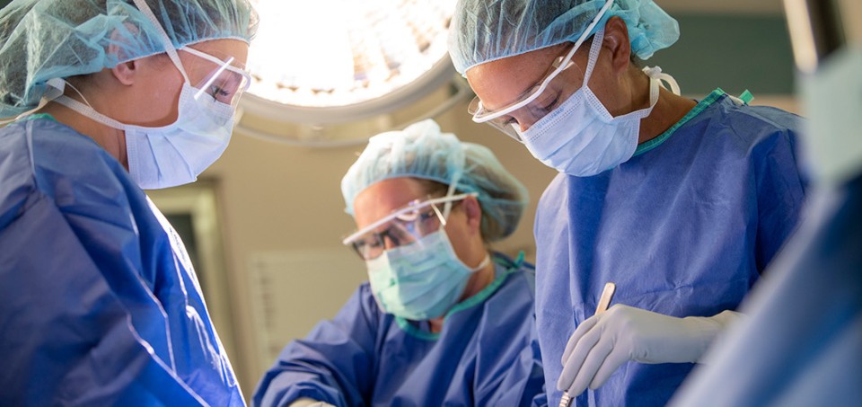 Doctors with masks and gloves performing a procedure