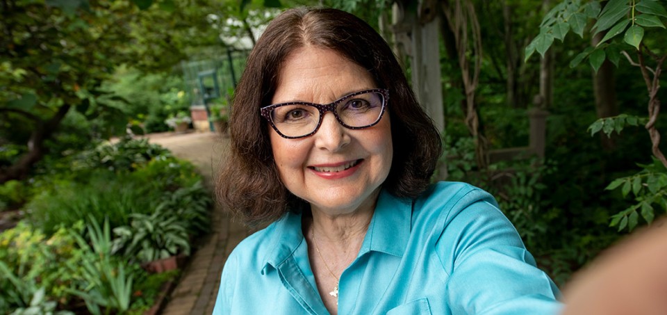 Woman smiling with trees and a footpath in the background