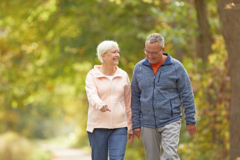 Elderly couple smiling and walking shoulder to shoulder