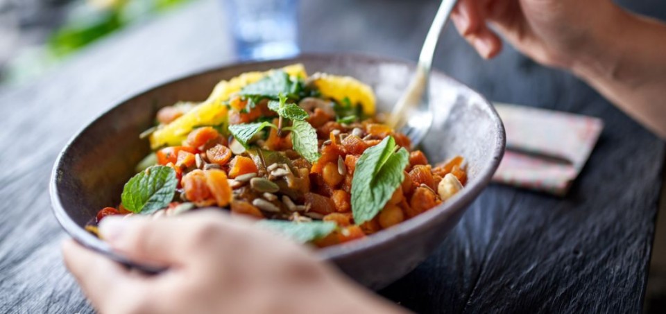 Hands holding a bowl of healthy food
