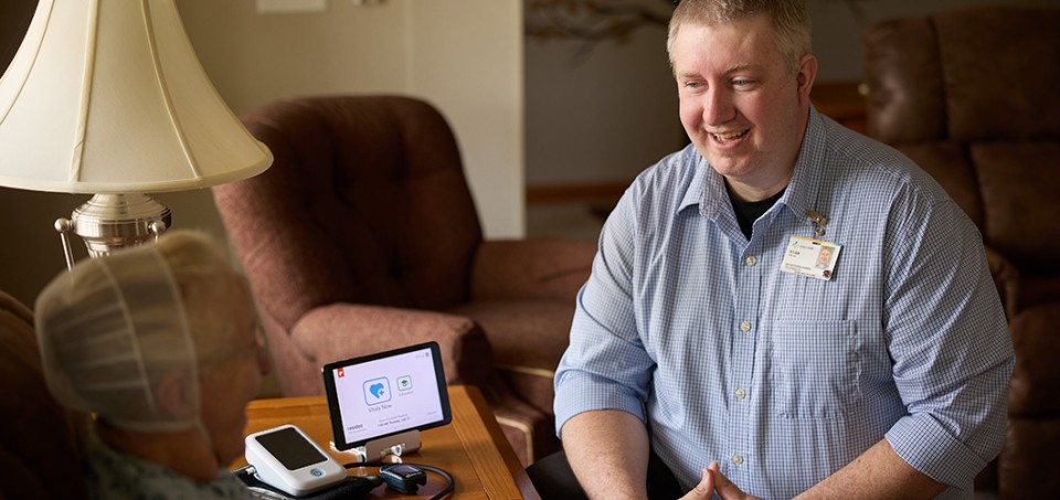 Doctor sitting across from patient with a small monitor on the table