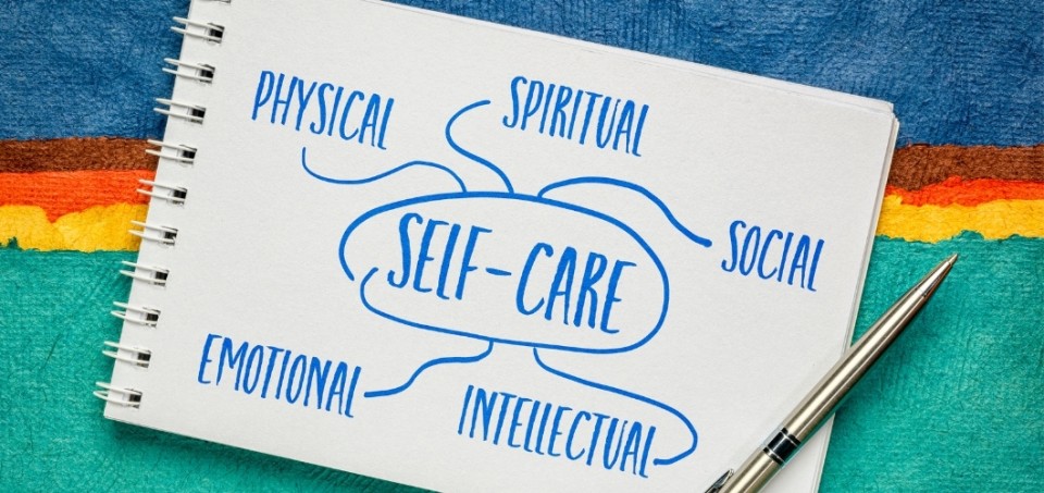 Notepad and pen with several single words describing aspects of self-care
