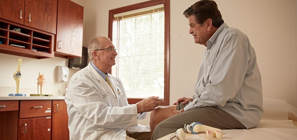 Doctor sitting with a patient who is on the examination table