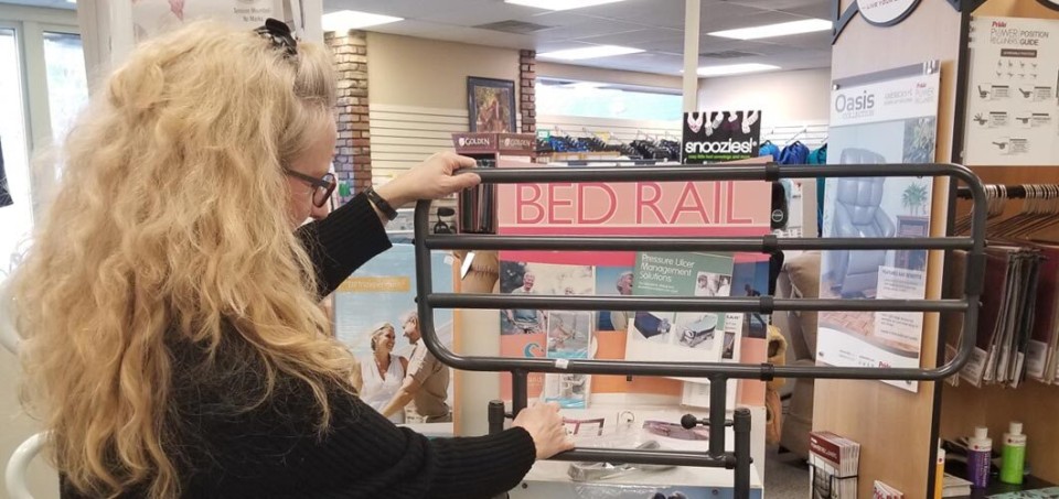 Woman standing in front of a bedrail