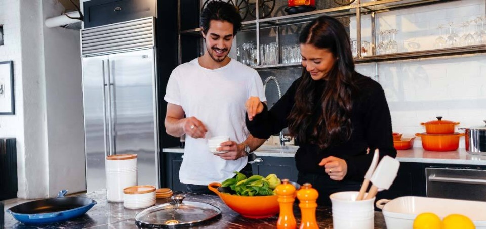 Man and woman cooking healthy food in a kitchen
