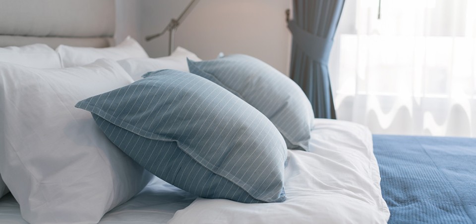 Bed with pillows in front of a window