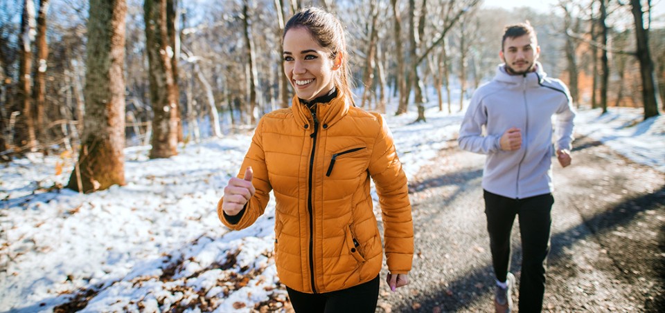 Couple walking on a park sidewalk during the winter