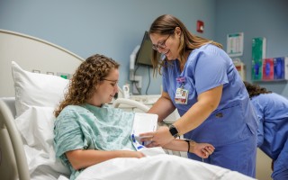 Nursing standing by the bedside taking a patient's blood pressure