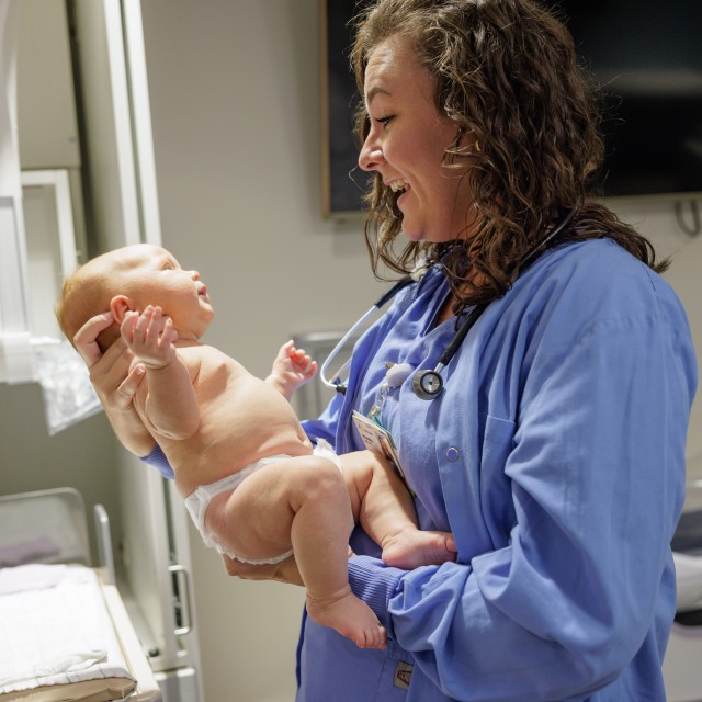 Nursing holding a newborn baby