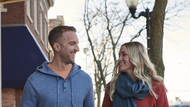 Couple looking at each other while walking on the sidewalk
