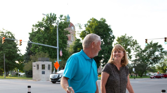 Couple walking their dog on the sidewalk in a downtown area