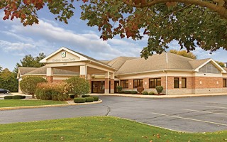 Goshen Surgery Center building with landscaping in the front and a parking area