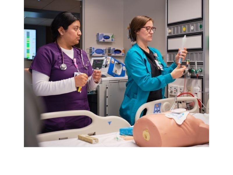 Two nurses practicing on a dummy
