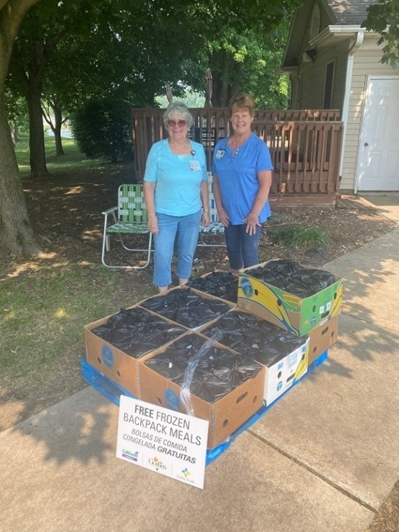 Two women standing in front of boxes