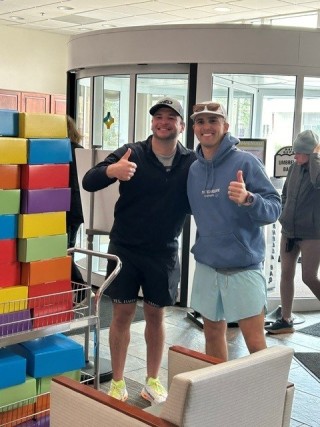 Two men giving the thumbs up in the hospital lobby