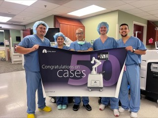 Doctors are standing shoulder to shoulder while holding a banner in a hospital
